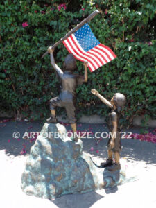 Raising Glory outdoor bronze garden sculpture of two children raising flag