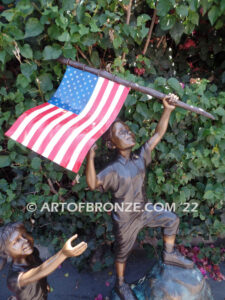 Raising Glory outdoor bronze garden sculpture of two children raising flag