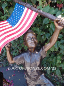 Raising Glory outdoor bronze garden sculpture of two children raising flag