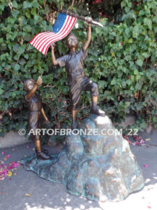 Raising Glory outdoor bronze garden sculpture of two children raising flag