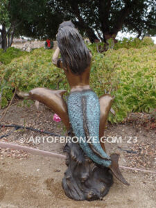 Bronze mermaid sea goddess statue swimming with dolphins holding shell for pond, pool or aquatic display