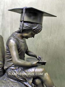 Global Scholars bronze statue of boy and girl sitting on globe reading book