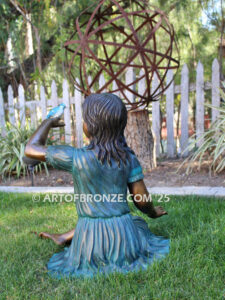 Wings of Joy bronze sculpture of sitting girl in dress with bronze bird perched on her hand