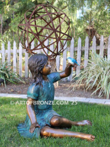 Wings of Joy bronze sculpture of sitting girl in dress with bronze bird perched on her hand