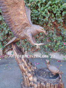 Dinner for Two falcon bronze statue of a life-size flying falcon into nest with baby falcon