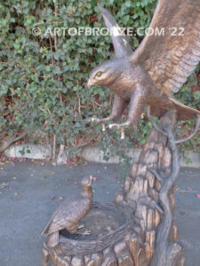 Dinner for Two falcon bronze statue of a life-size flying falcon into nest with baby falcon