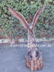 Dinner for Two falcon bronze statue of a life-size flying falcon into nest with baby falcon